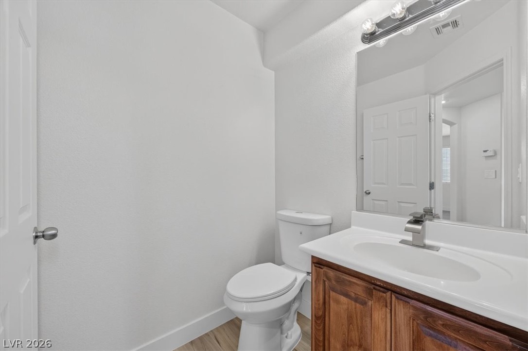 552 Albacate Street Henderson, NV 89015 - Photo 17 of 40 A well-lit powder room offers contemporary fixtures and wood-look flooring.