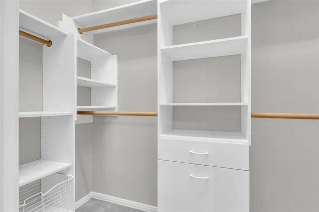 a view of walk in closet with empty racks