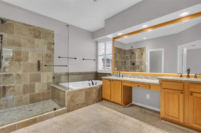 a large spacious bathroom with a tub a double vanity sink a mirror and a bathtub
