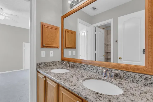 a bathroom with a granite countertop sink and a mirror