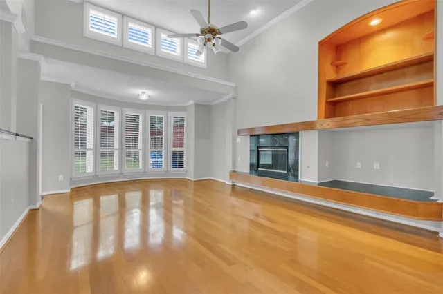 a view of an empty room with a window and fireplace