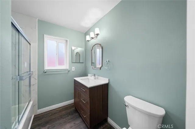 a bathroom with a toilet sink vanity and mirror