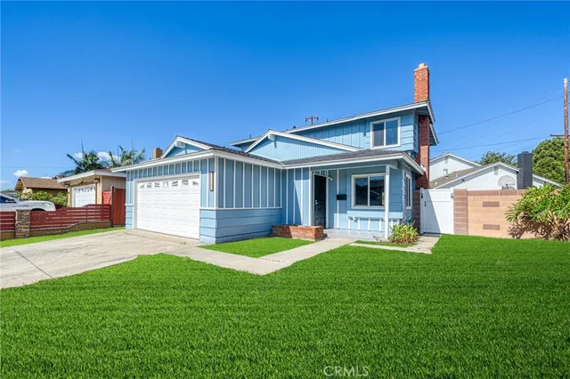 a view of a house with a yard and a patio