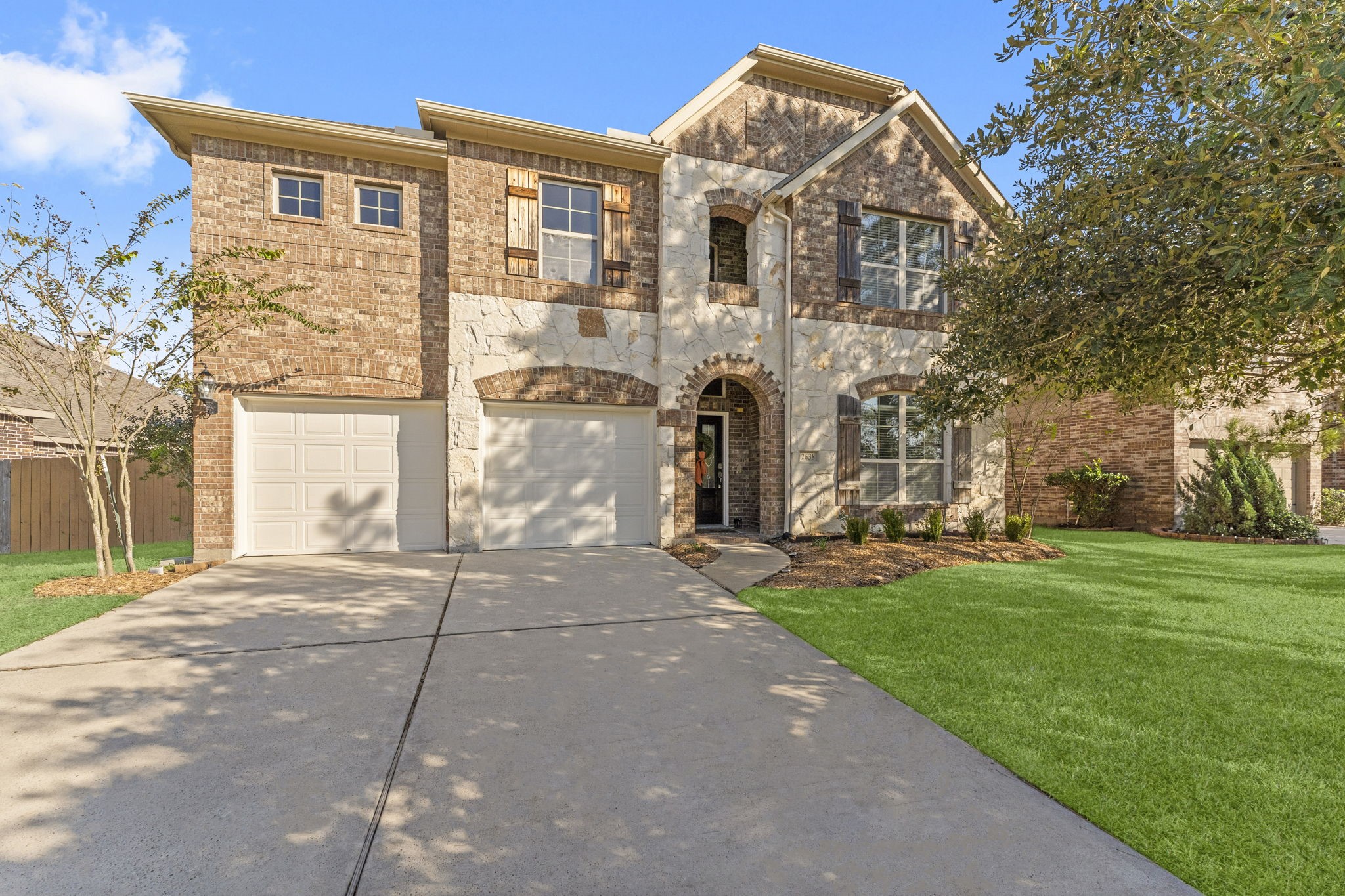 Beautiful brick and stone elevation with shutter accents, a covered front entry and double-wide driveway. Well-manicured landscaping and mature trees provide inviting curb appeal for this stunning two-story home in Harmony Creek.