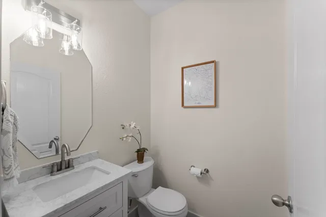 a bathroom with a sink mirror vanity and toilet