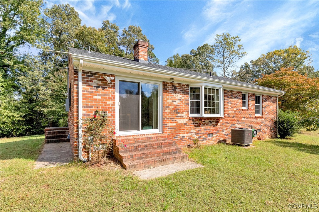 3050 Rose Mount Road Walkerton, VA 23177 - Photo 23 of 35 Rear view of house featuring a lawn and central AC