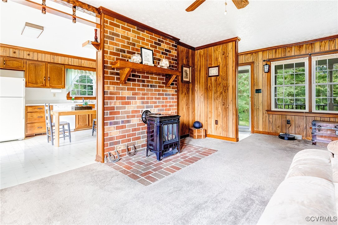 3050 Rose Mount Road Walkerton, VA 23177 - Photo 7 of 35 Living room with wood walls, a wood stove, crown m