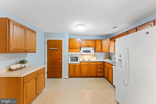 a kitchen with stainless steel appliances granite countertop a refrigerator a sink dishwasher a oven with large countertops