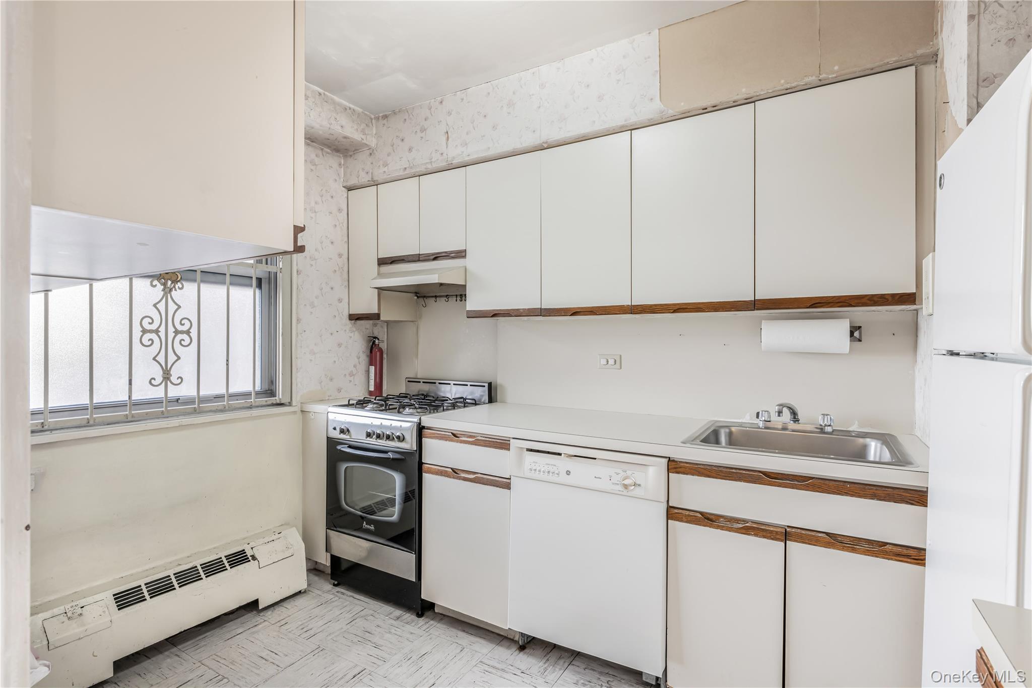 61-25 97th Street, Unit 15F Queens, NY 11374 - Photo 12 of 26 a kitchen with white cabinets and white appliances