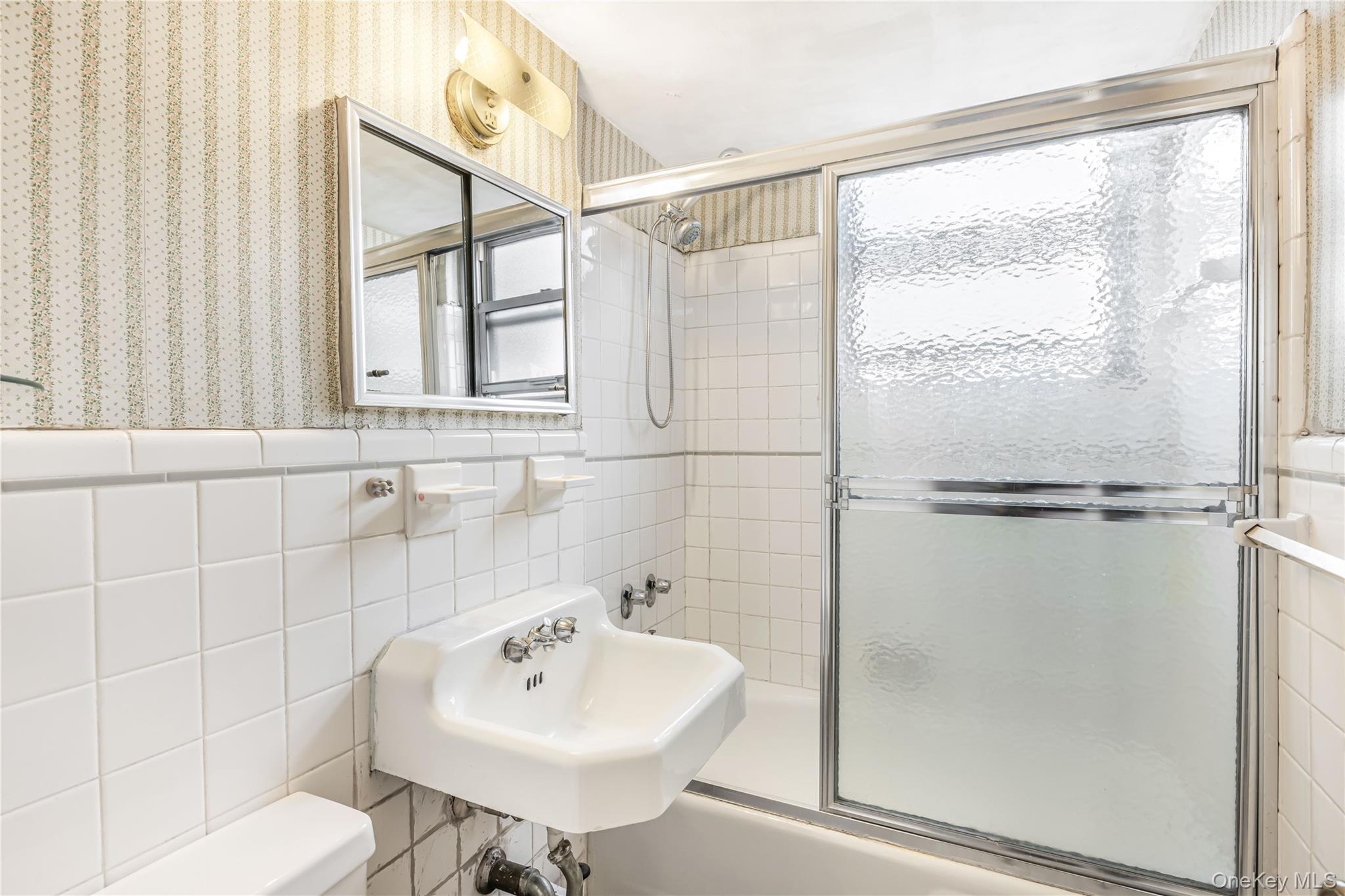 61-25 97th Street, Unit 15F Queens, NY 11374 - Photo 19 of 26 a bathroom with a sink shower and a toilet