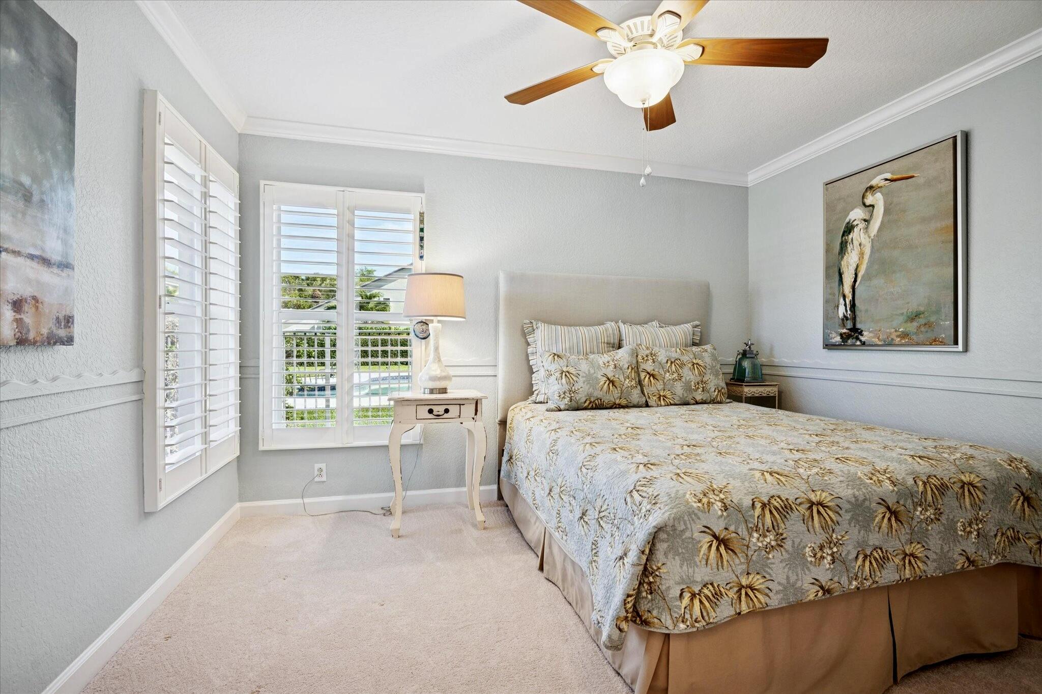7299 Serrano Terrace Delray Beach, FL 33446 - Photo 20 of 39 a bedroom with a large bed and a chandelier fan