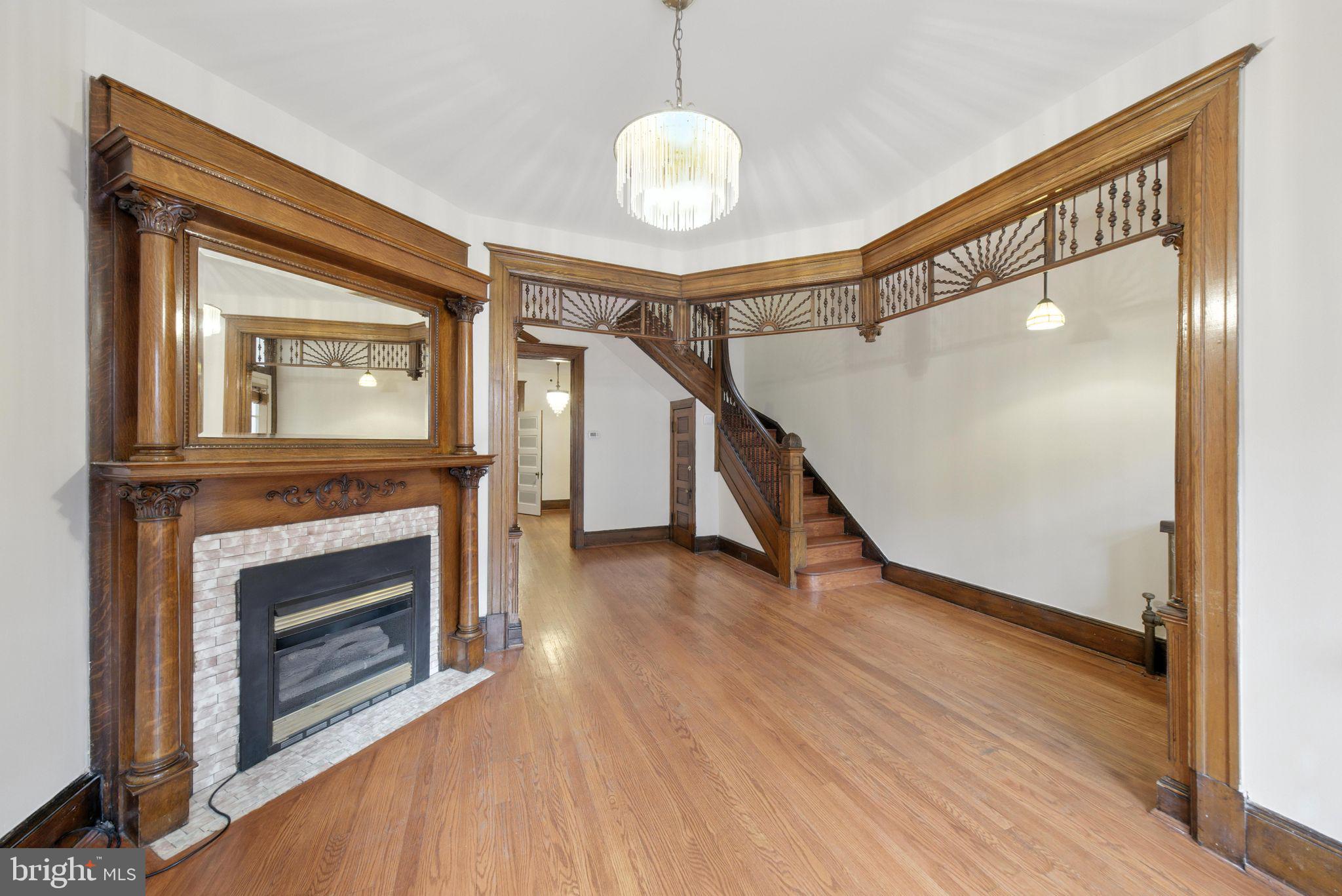 1763 U Street Northwest Washington, DC 20009 - Photo 4 of 29 a view of an empty room with wooden floor a fireplace and a window