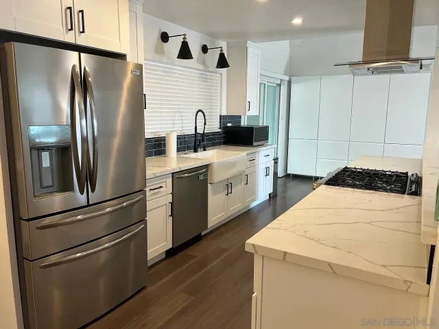 a kitchen with stainless steel appliances a refrigerator sink and cabinets