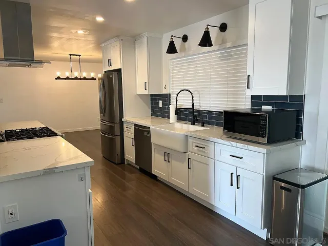 a kitchen with stainless steel appliances granite countertop a sink a stove and a refrigerator