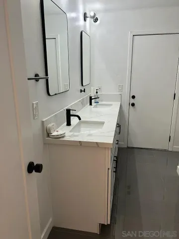 a bathroom with a double vanity sink and mirror