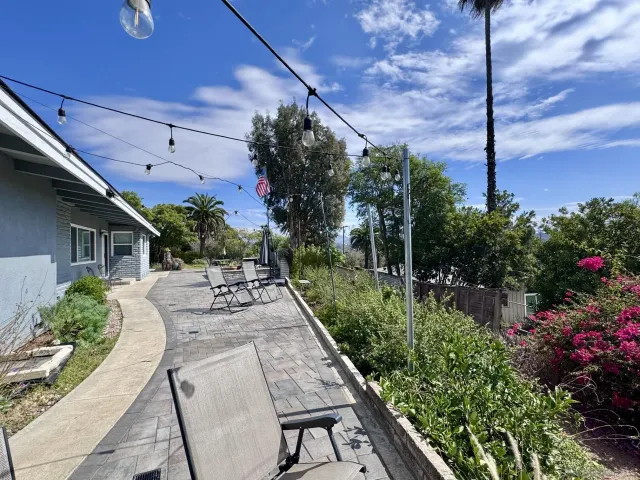 a view of a patio with table and chairs potted plants