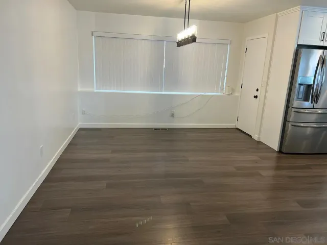an empty room with wooden floor and natural light