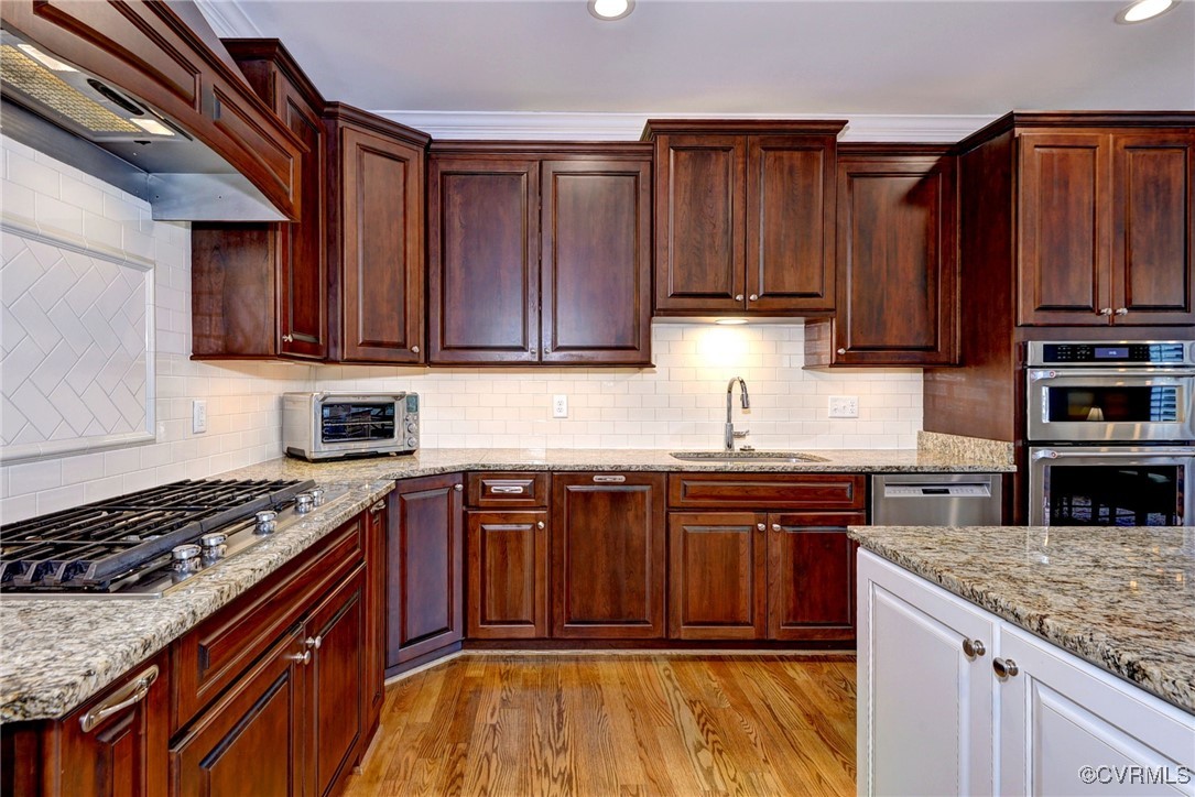 104 Edenbridge Williamsburg, VA 23188 - Photo 11 of 50 a kitchen with stainless steel appliances granite countertop a stove a sink dishwasher and cabinets with wooden floor