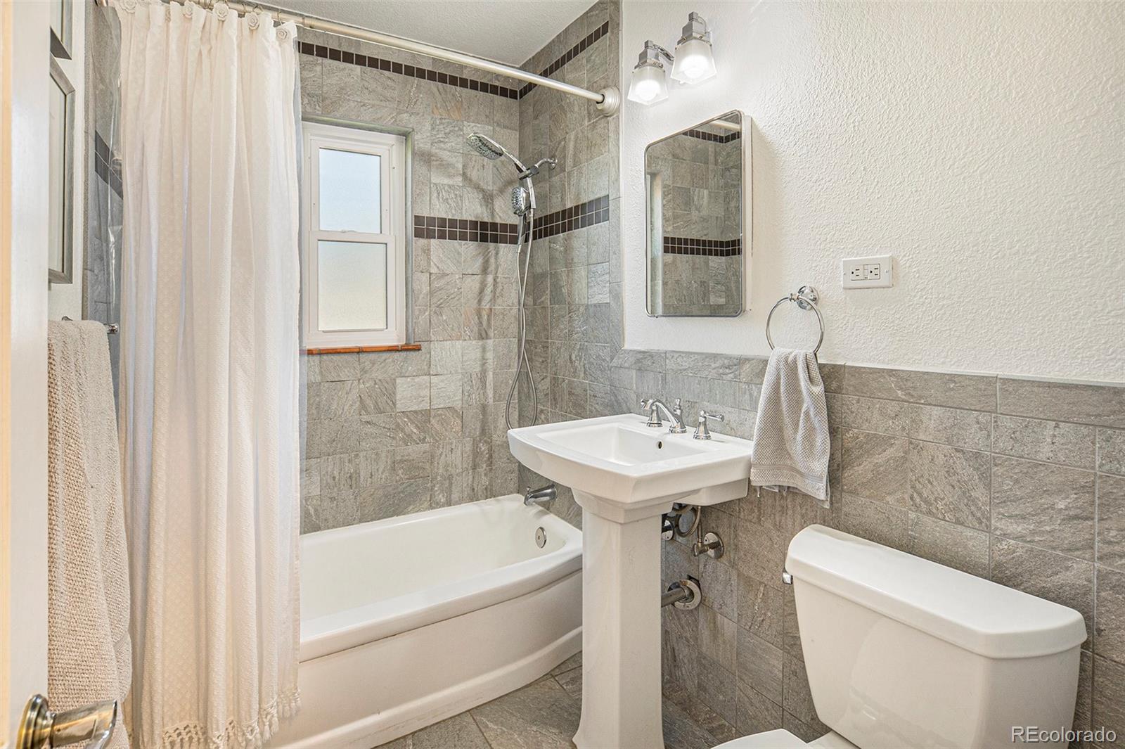 3621 Oneida Street Denver, CO 80207 - Photo 14 of 35 a bathroom with a sink a toilet and shower