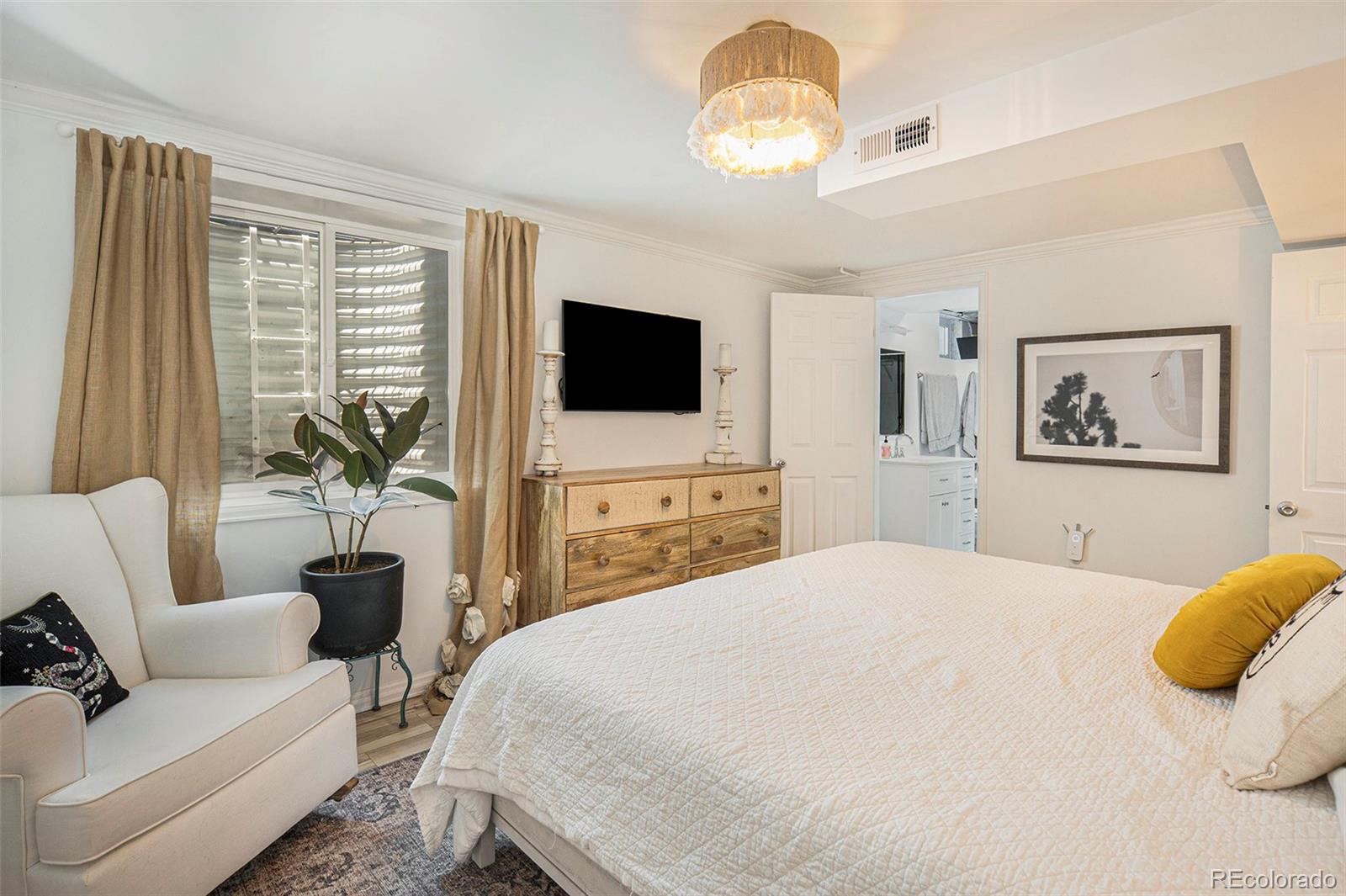 3621 Oneida Street Denver, CO 80207 - Photo 17 of 35 a bedroom with a bed and a flat screen tv