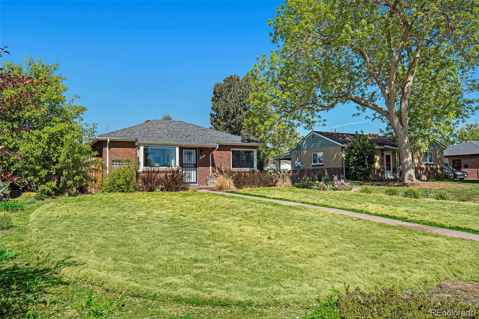 3621 Oneida Street Denver, CO 80207 - Photo 3 of 35 a front view of a house with a garden