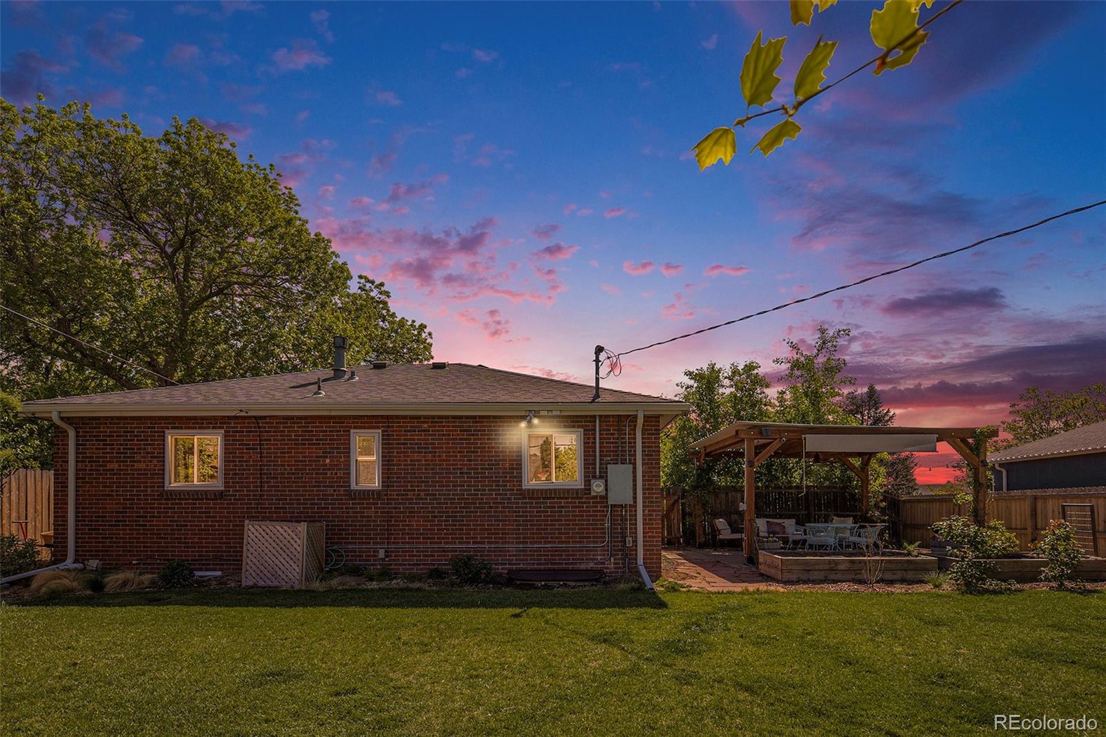 3621 Oneida Street Denver, CO 80207 - Photo 31 of 35 a view of a house with a big yard potted plants and a large tree