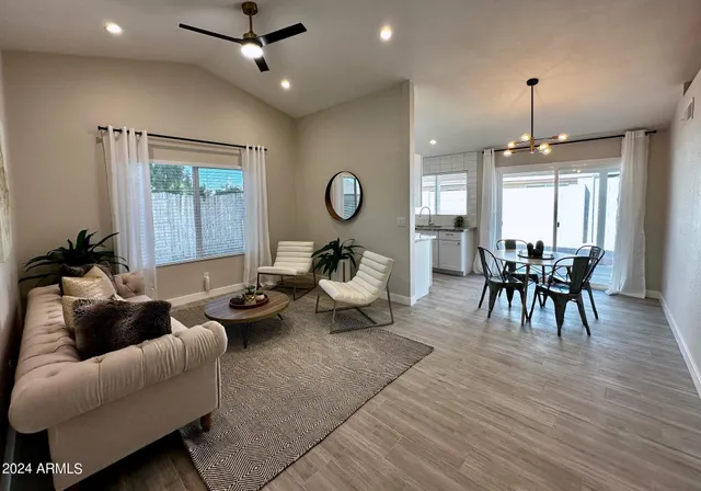 a living room with furniture a table and wooden floor