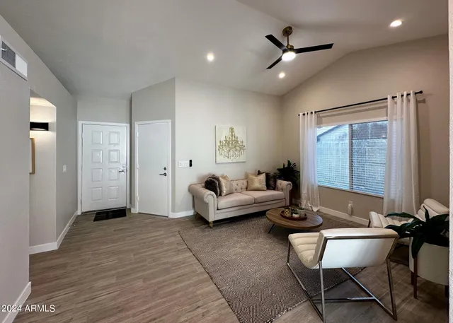a living room with furniture and a ceiling fan
