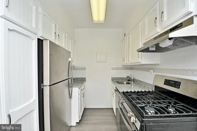 a kitchen with stainless steel appliances granite countertop a refrigerator and a stove
