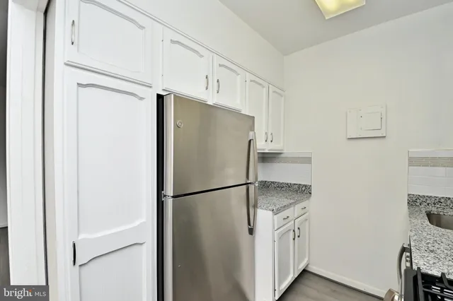 a kitchen with stainless steel appliances granite countertop a refrigerator and a stove top oven