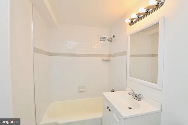 a bathroom with a bathtub a shower a sink and a window