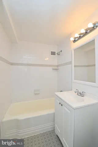 a bathroom with a tub sink and mirror