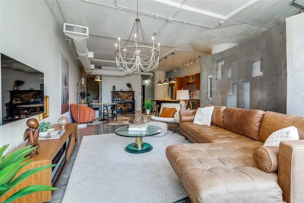 a living room with furniture kitchen view and a chandelier