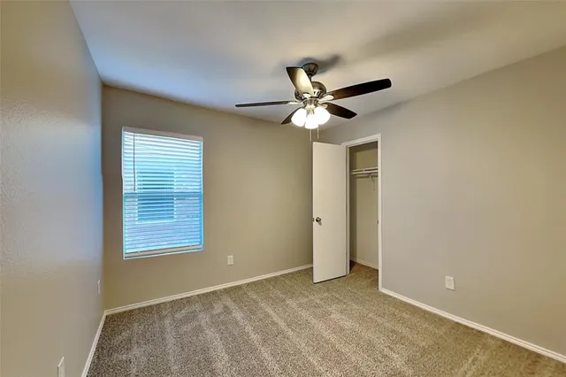 a view of an empty room with a chandelier fan