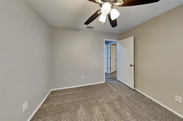 an empty room with a window and a ceiling fan