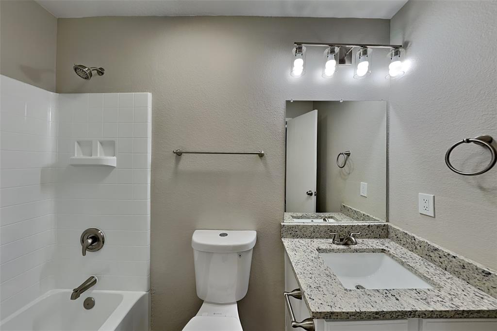 8844 Quarry Ridge Trail Fort Worth, TX 76244 - Photo 13 of 18 Bathroom with washtub / shower combination, vanity, and a textured wall