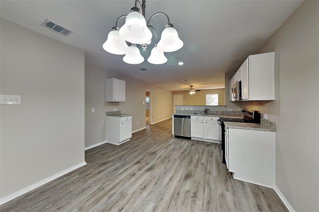 8844 Quarry Ridge Trail Fort Worth, TX 76244 - Photo 17 of 18 Kitchen with a chandelier, appliances with stainless steel finishes, open floor plan, and white cabinetry
