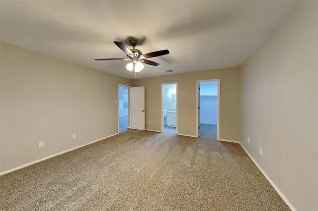 a view of an empty room with a chandelier fan