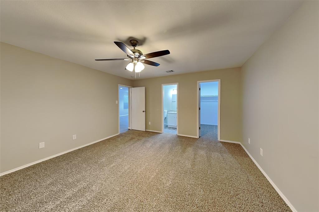 8844 Quarry Ridge Trail Fort Worth, TX 76244 - Photo 6 of 18 Unfurnished bedroom with a walk in closet, carpet floors, ensuite bathroom, and a ceiling fan