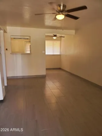 an empty room with windows and fan
