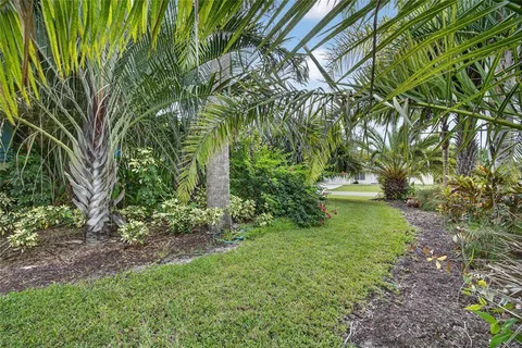 a patio with table and chairs and potted plants