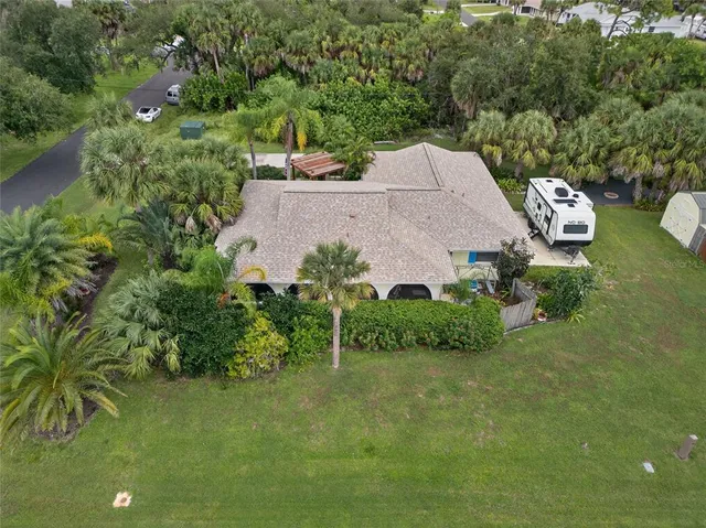 an aerial view of a house with a garden and lake view