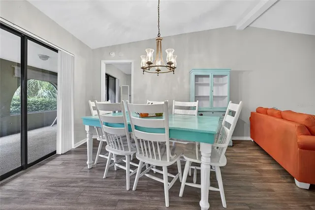 a dining room with furniture a chandelier and wooden floor