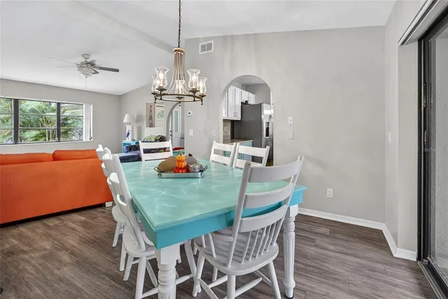 a kitchen with stainless steel appliances a table chairs sink and cabinets