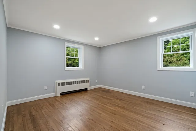 a view of a room with wooden floor and windows