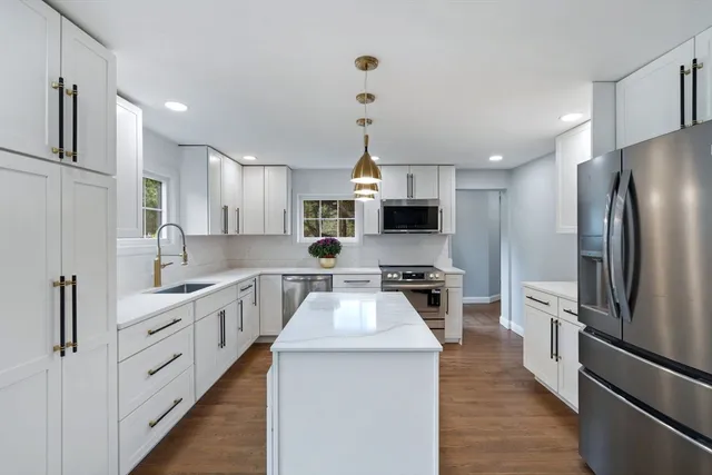 a kitchen with white cabinets and stainless steel appliances