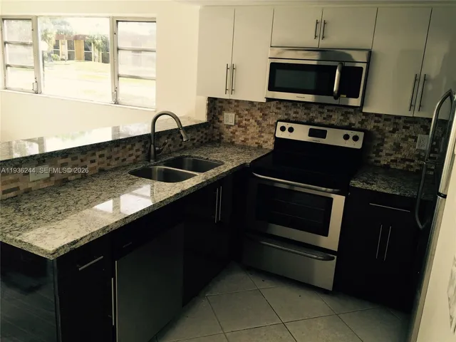 a kitchen with a sink stove and microwave