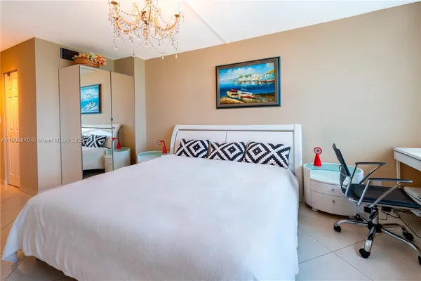 a bedroom with a large bed and a chandelier