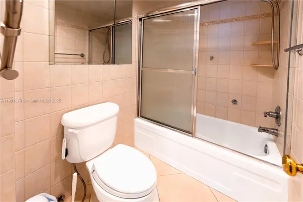 a white toilet sitting next to a bath tub and a shower