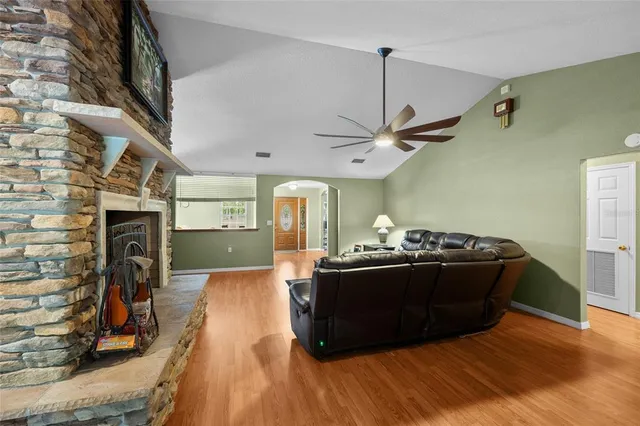 a kitchen with stainless steel appliances granite countertop a refrigerator a stove top oven a sink dishwasher a dining table and chairs with wooden floor